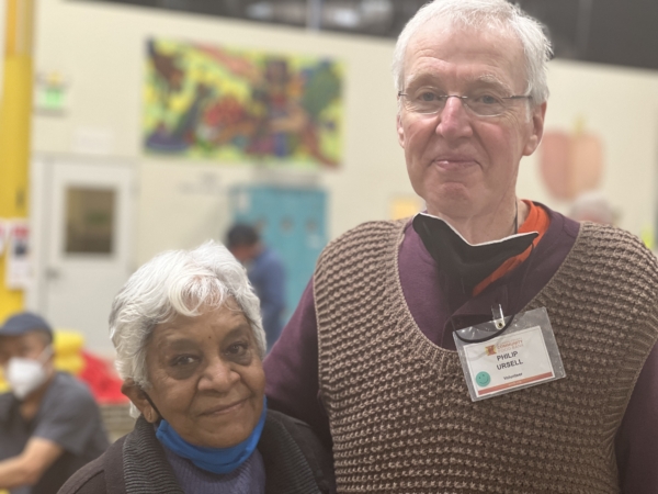 Volunteers Shantha and Philip, who have been volunteering together at ACCFB since 2020, standing together and smiling in the Community Engagement Center