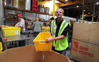 Volunteer sorting boxes of apples