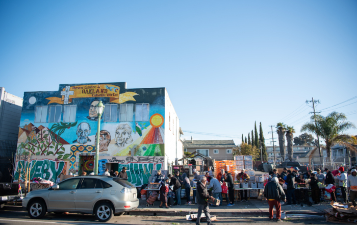 A food distribution in front of a mural
